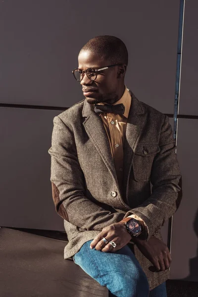 Elegante hombre de traje sentado sobre hormigón - foto de stock