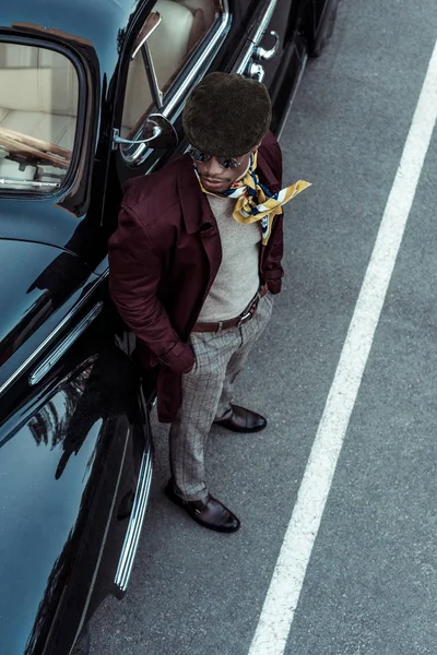 Homme afro-américain à la mode posant avec une voiture — Photo de stock
