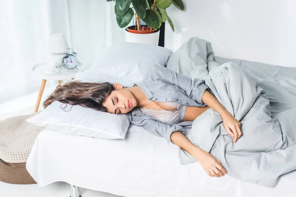 Giovane donna in lingerie sul letto — Foto stock