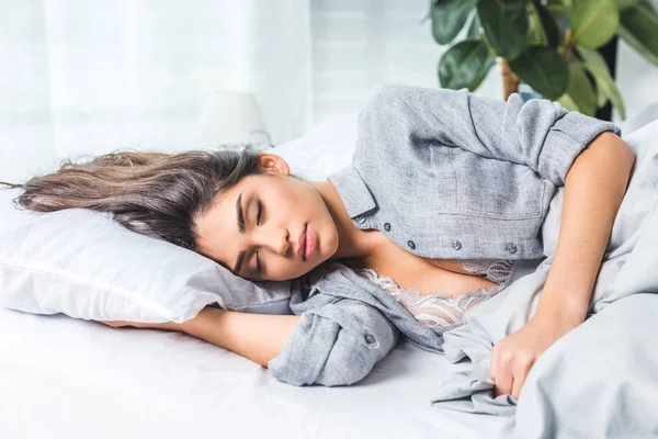 Junge Frau in Dessous auf dem Bett — Stockfoto