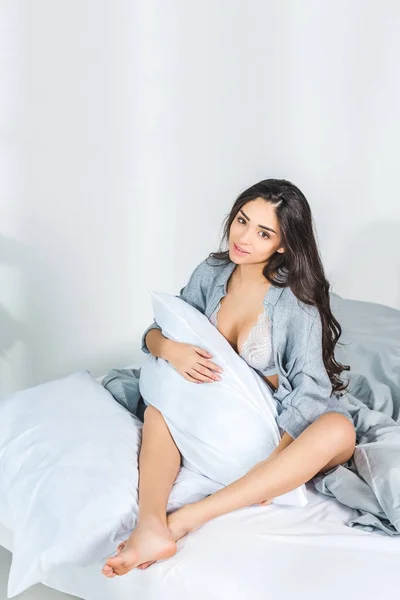 Donna sexy seduta sul letto — Foto stock
