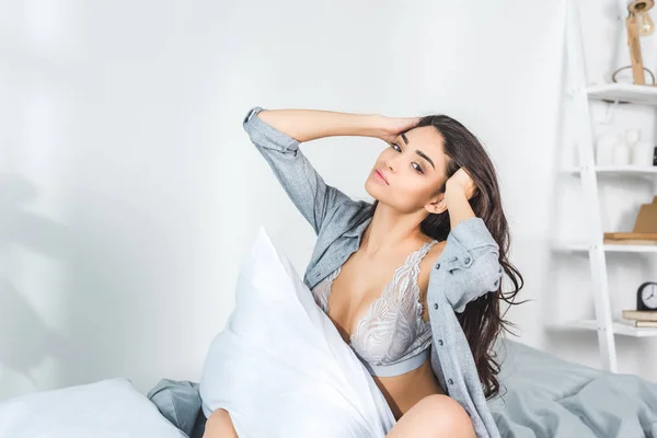 Femme sexy assise sur le lit — Photo de stock