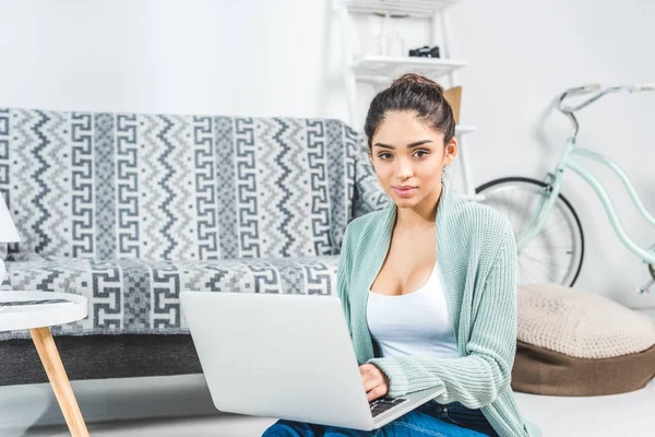 Jeune femme avec ordinateur portable à la maison — Photo de stock