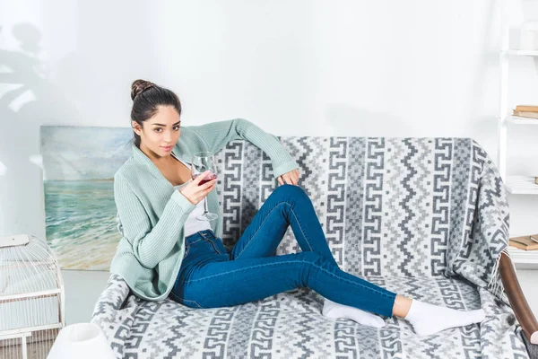 Mujer joven bebiendo vino en casa - foto de stock