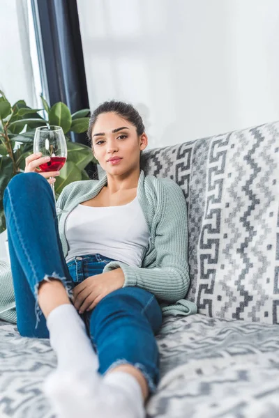 Mujer joven bebiendo vino en casa - foto de stock