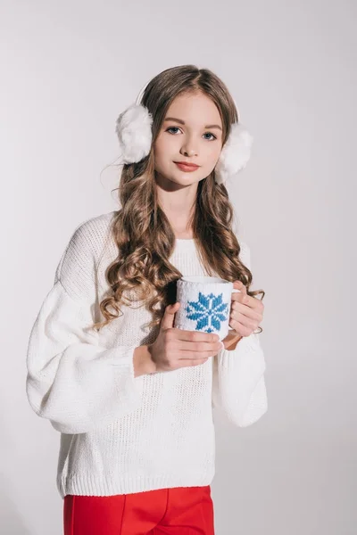 Girl in fur earmuffs holding cup — Stock Photo