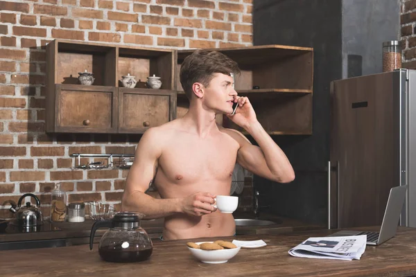 Uomo che parla per telefono in cucina — Foto stock