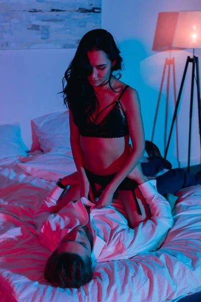 Mulher em lingerie sentado no namorado — Fotografia de Stock