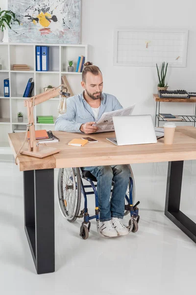 Disabled man reading newspaper — Stock Photo