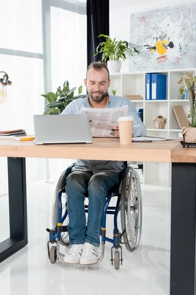 Disabled businessman reading newspaper — Stock Photo
