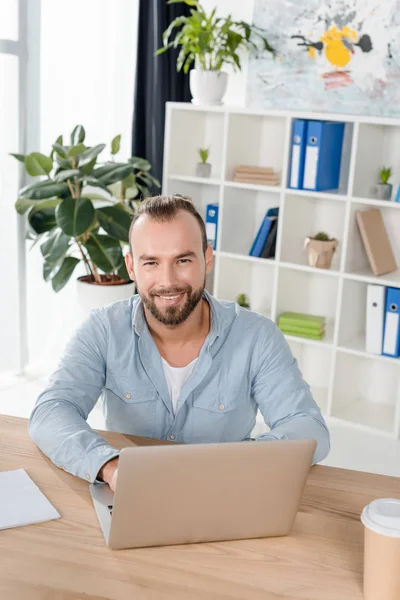 El hombre trabajando con el ordenador portátil - foto de stock