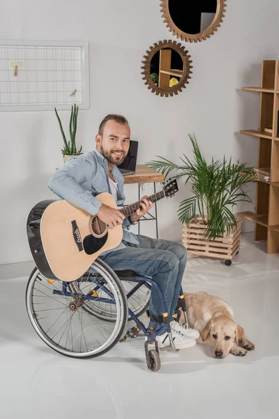 Man on wheelchair playing guitar — Stock Photo