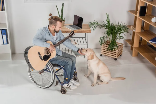 Behinderter Mann mit Gitarre Streichelhund — Stockfoto