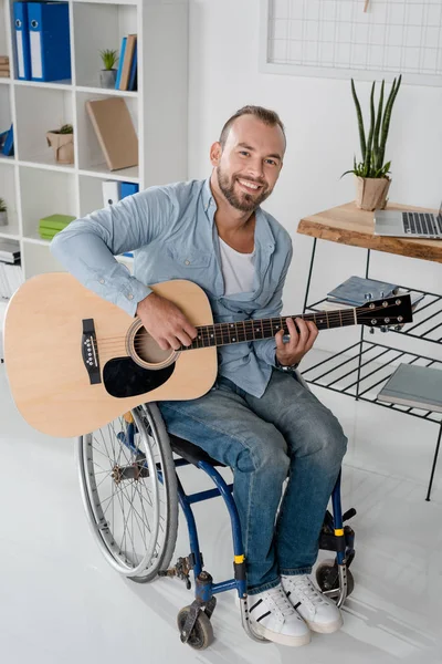 Людина на інвалідному візку грає на гітарі — стокове фото