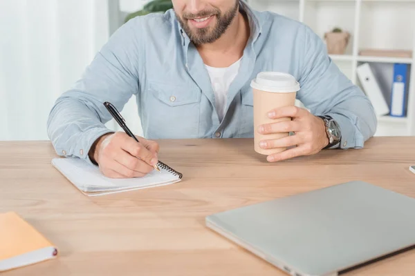 Mann schreibt in Notizbuch — Stockfoto
