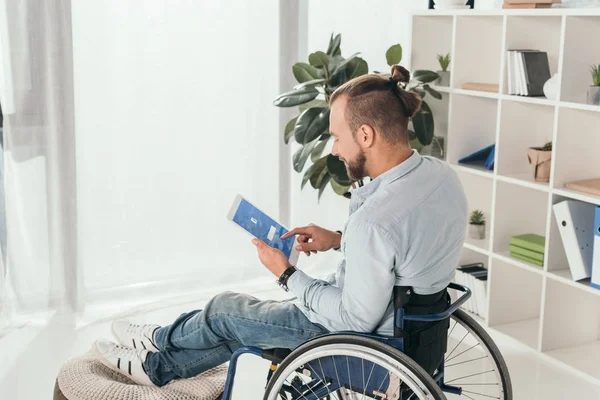 Homme en fauteuil roulant utilisant la tablette — Photo de stock