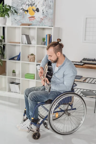 Man on wheelchair playing guitar — Stock Photo
