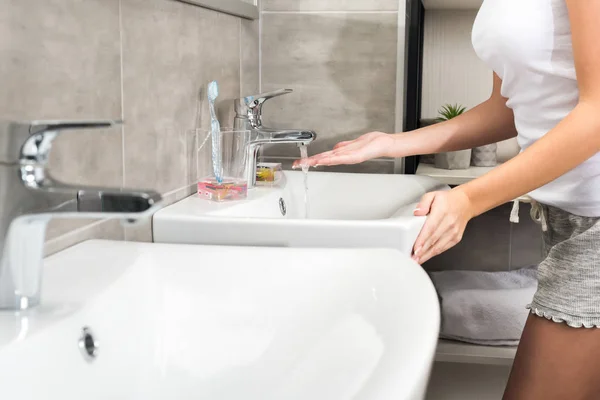 Girl putting hand under water — Stock Photo