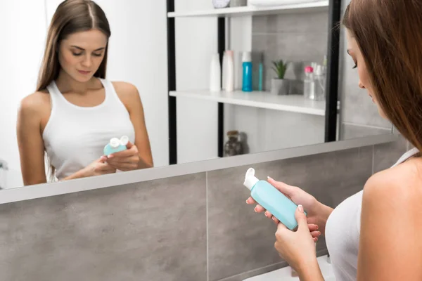 Girl reading lotion description — Stock Photo