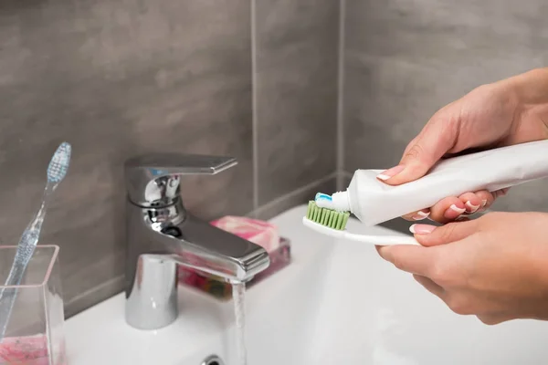 Girl applying toothpaste on toothbrush — Stock Photo