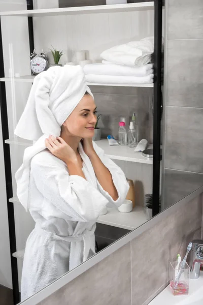 Mujer sonriente de pie en el baño - foto de stock