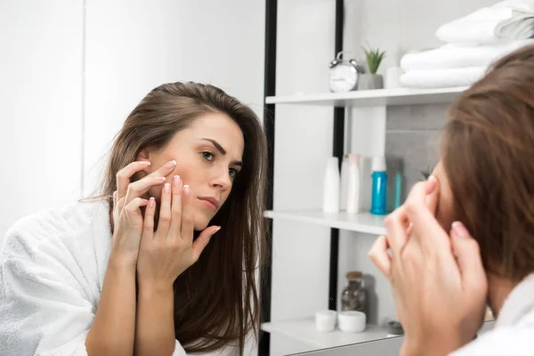 Mujer comprobar la piel de la cara - foto de stock