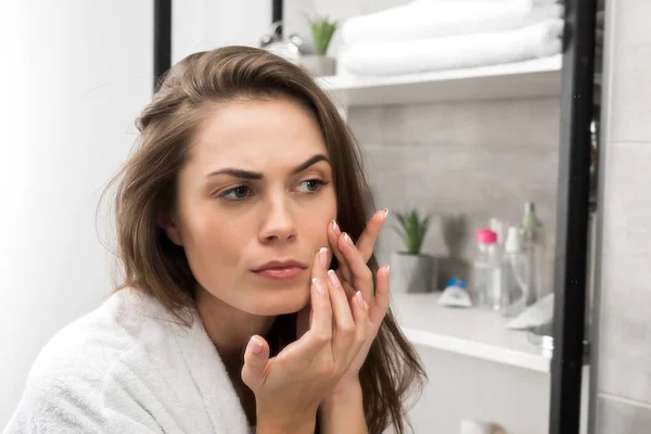 Жінка перевіряє шкіру обличчя — стокове фото