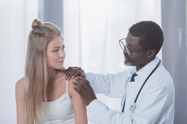 Médico examinando paciente hombro - foto de stock
