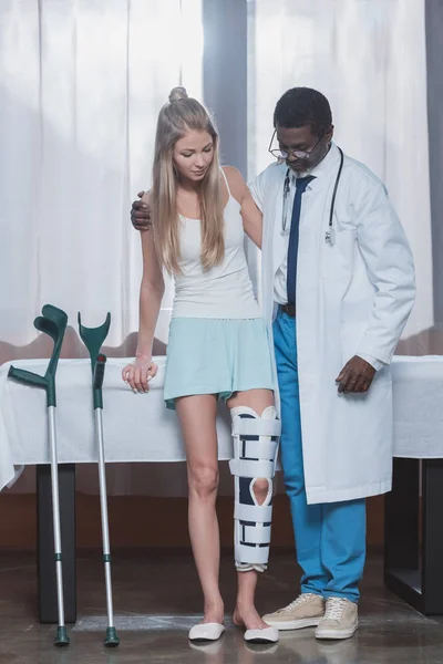 Doctor helping patient stand up — Stock Photo