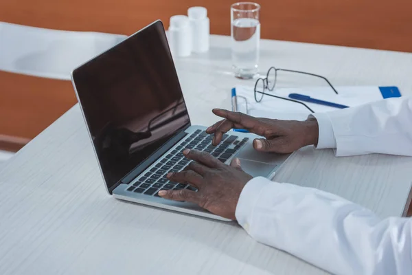 Доктор печатает на ноутбуке — стоковое фото