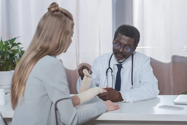 Doctor bandaging patient hand — Stock Photo