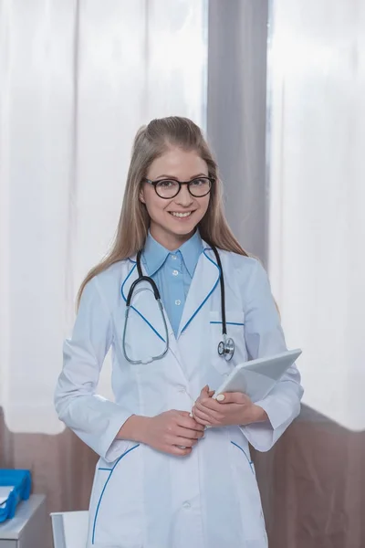 Doctor standing with tablet — Stock Photo