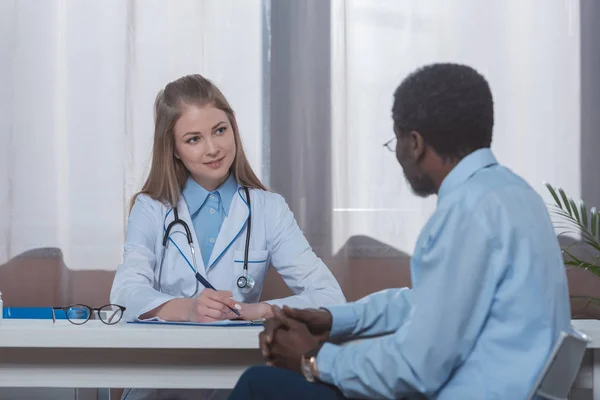 Doctor sitting and listening patient — Stock Photo