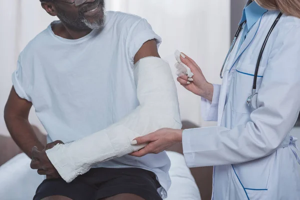 Doctor bandaging patient hand — Stock Photo