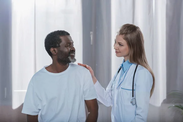 Cheerful doctor and smiling patient — Stock Photo