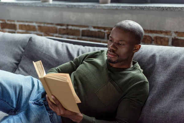 Hombre afroamericano leyendo libro - foto de stock