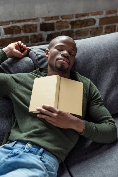 Africano americano hombre durmiendo en sofá - foto de stock