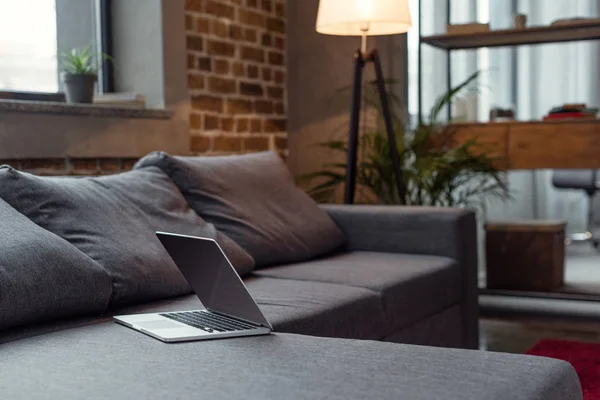 Opened laptop on sofa — Stock Photo