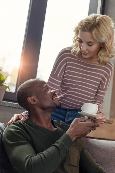 Retrato de mulher trouxe xícara de café para sorrindo namorado americano africano — Fotografia de Stock