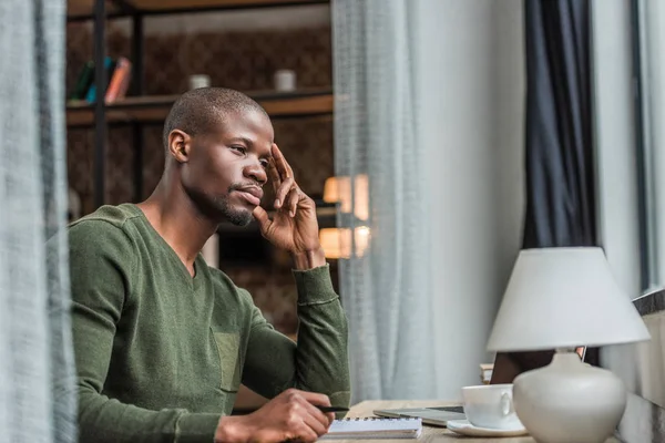 Nachdenklicher afrikanisch-amerikanischer Mann arbeitet zu Hause — Stockfoto