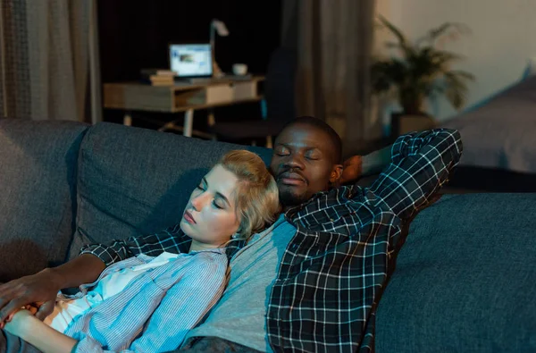 Multicultural couple sleeping on sofa together at home — Stock Photo