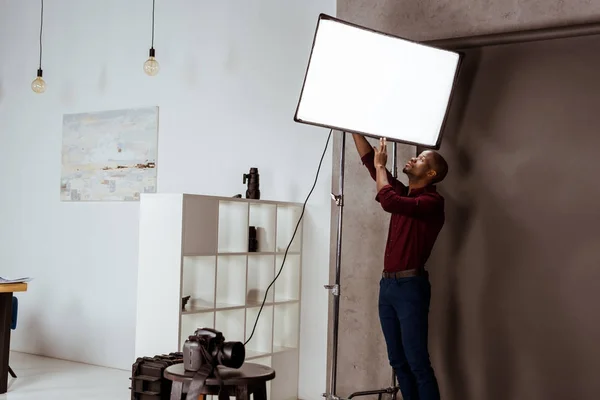 Fotografo afroamericano si prepara per il servizio fotografico in studio — Foto stock