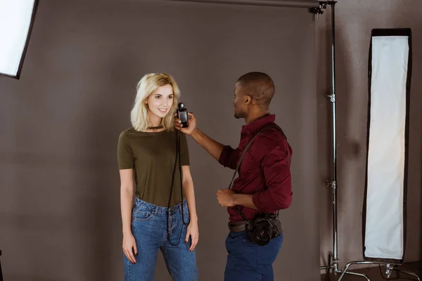 Fotógrafo afro-americano e modelo caucasiano tendo sessão fotográfica em estúdio — Fotografia de Stock