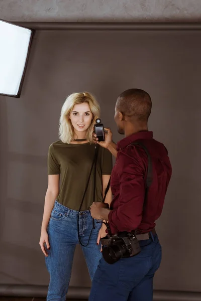 African american photographer and caucasian model having photoshoot in studio — Stock Photo
