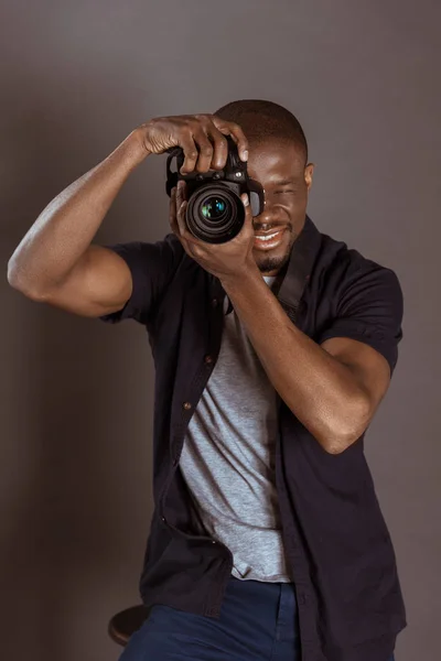 Retrato de fotógrafo afroamericano tomando fotos en cámara fotográfica - foto de stock