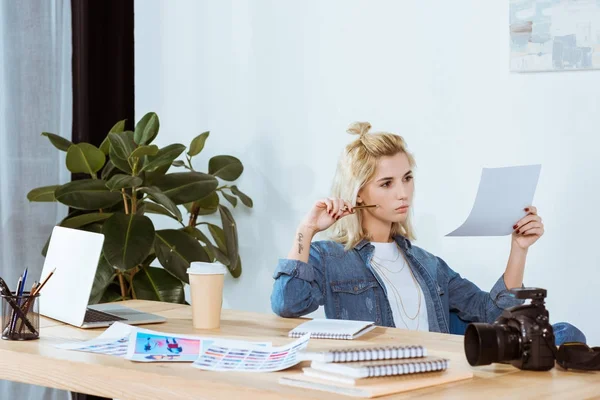 Ritratto di fotografo premuroso che guarda esempi di photoshoot sul posto di lavoro in ufficio — Foto stock