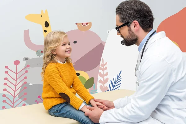 Pediatra cogido de la mano de niña — Stock Photo