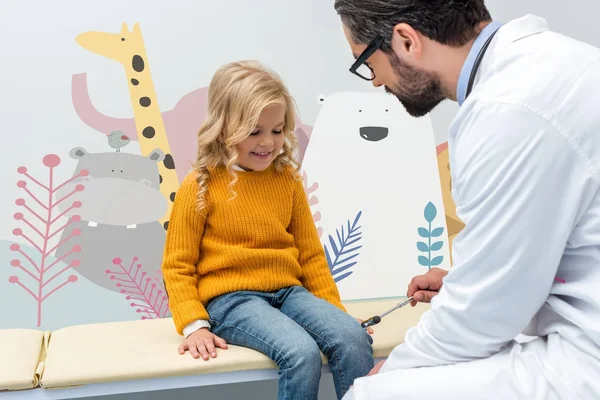 Pediatra haciendo examen de neurología para niña - foto de stock