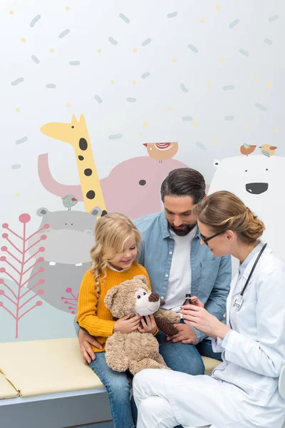 Médico dando jarabe al osito de peluche - foto de stock