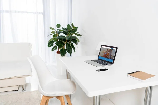 Oficina en casa con ordenador portátil, smartphone y portátil en la mesa — Stock Photo
